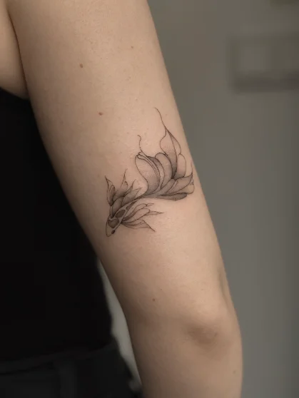Ilustracyjny tatuaż fine line kwiatu na ramieniu